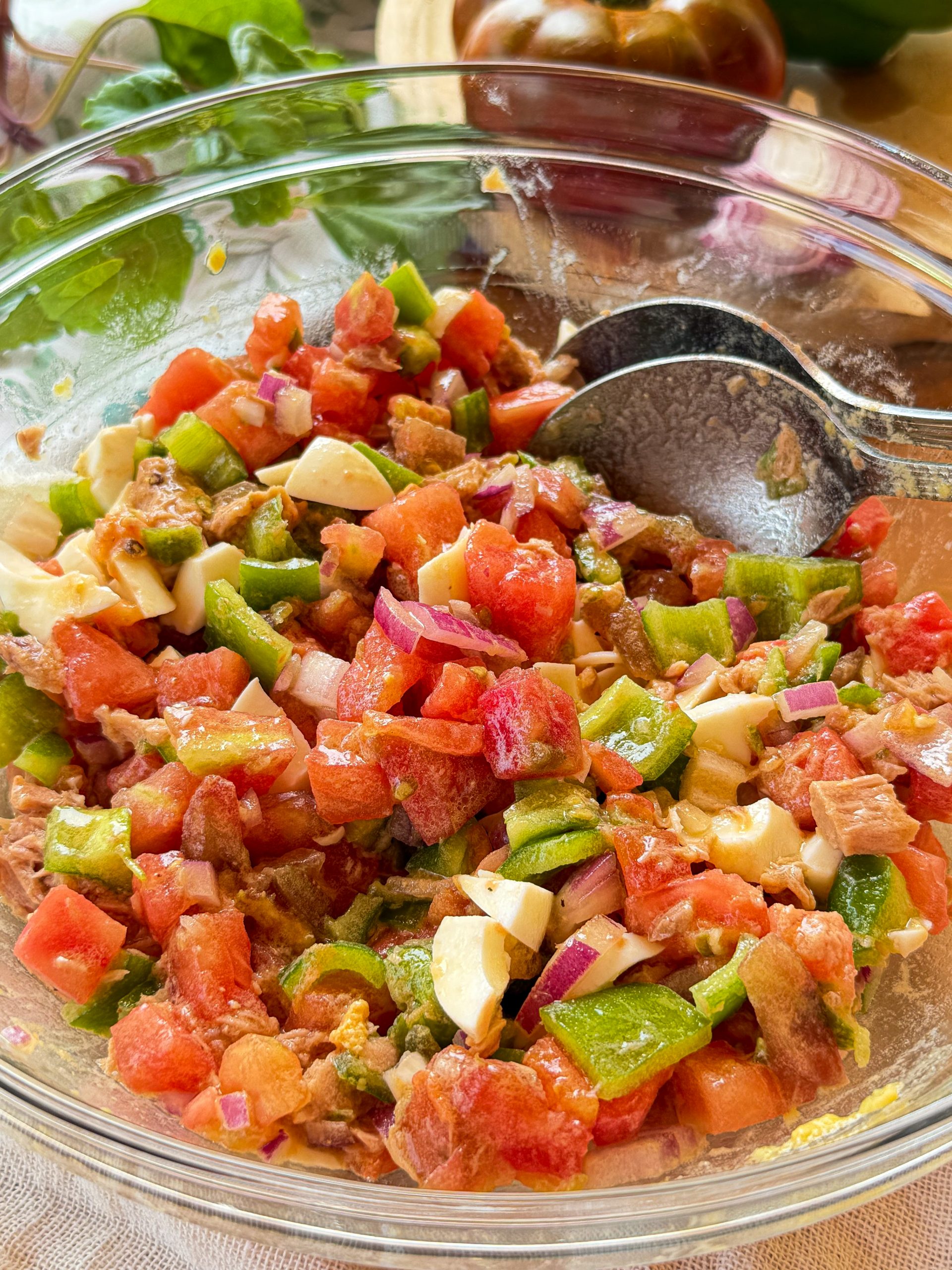 Bol de cristal con pipirrana andaluza tradicional recién hecha, mostrando el corte en brunoise del tomate maduro, pimiento verde, cebolla, atún y huevo duro.