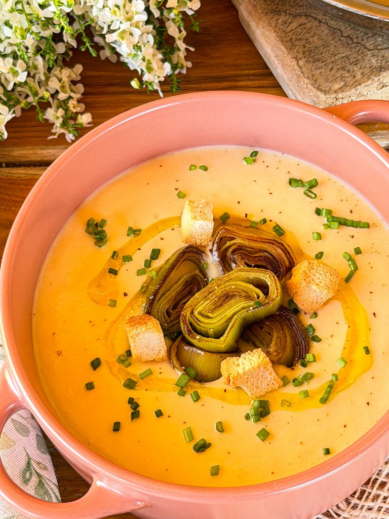 Vichyssoise casera servida en bol rosa con puerros confitados y picatostes
