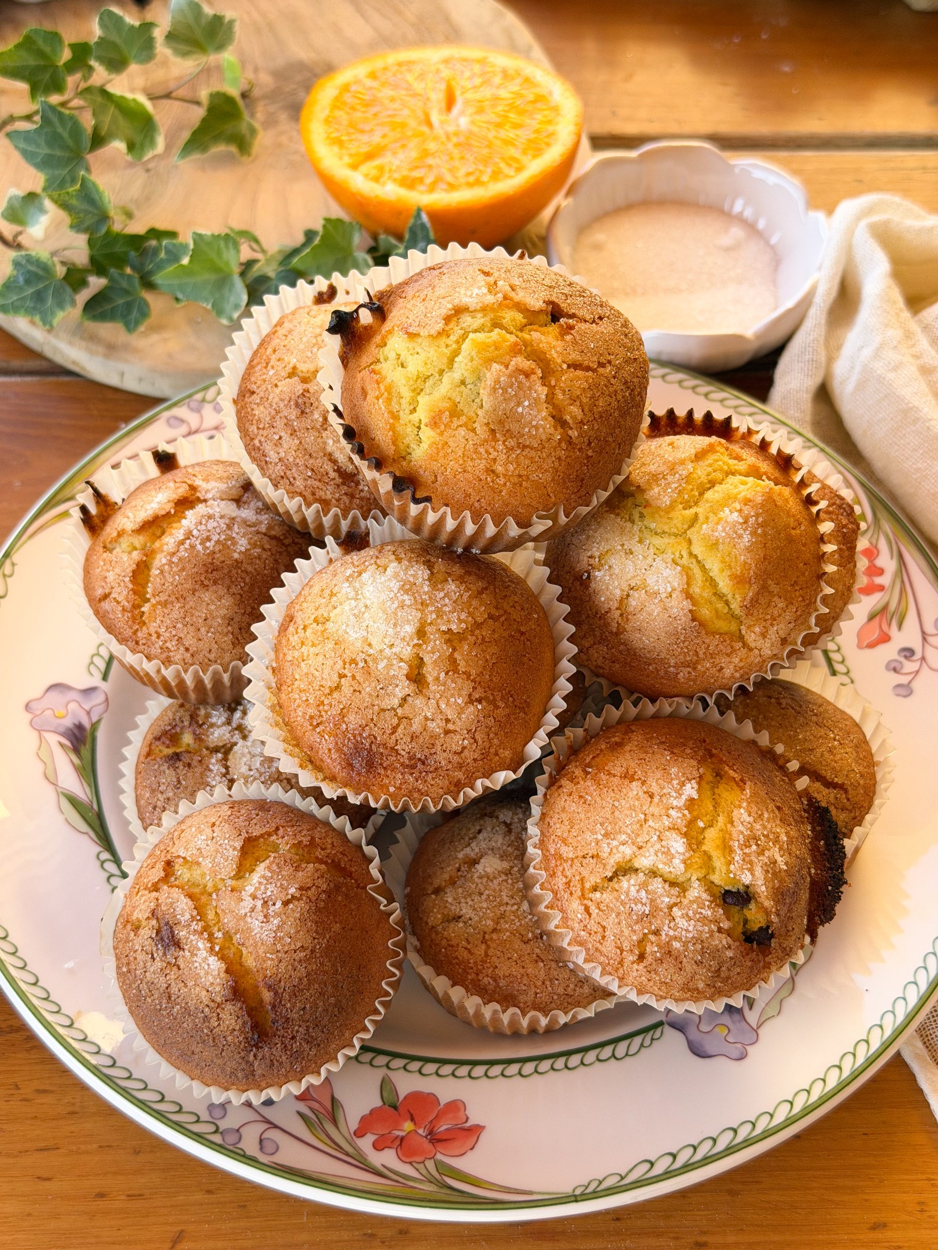 Magdalenas de naranja y chocolate esponjosas con copete alto y costra crujiente de azúcar. Receta casera fácil para preparar magdalenas de naranja jugosas con pepitas de chocolate.