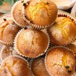 Magdalenas de naranja y chocolate esponjosas con copete alto y costra crujiente de azúcar. Receta casera fácil para preparar magdalenas de naranja jugosas con pepitas de chocolate.