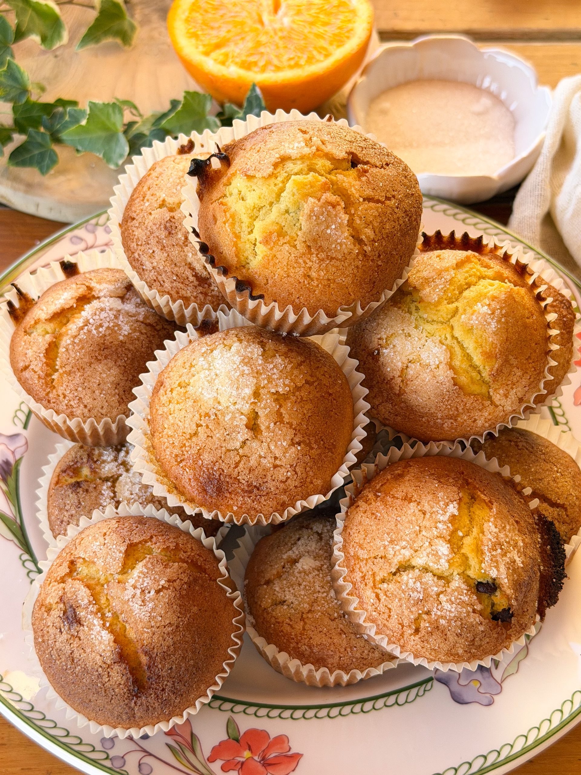 Magdalenas de naranja y chocolate esponjosas con copete alto y costra crujiente de azúcar. Receta casera fácil para preparar magdalenas de naranja jugosas con pepitas de chocolate.