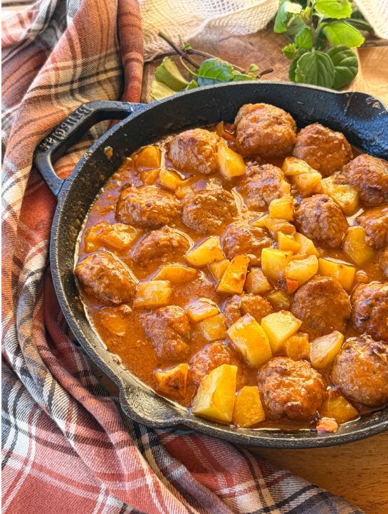 Albóndigas en salsa caseras con patatas al horno, una receta tradicional con salsa de verduras y caldo de pollo.