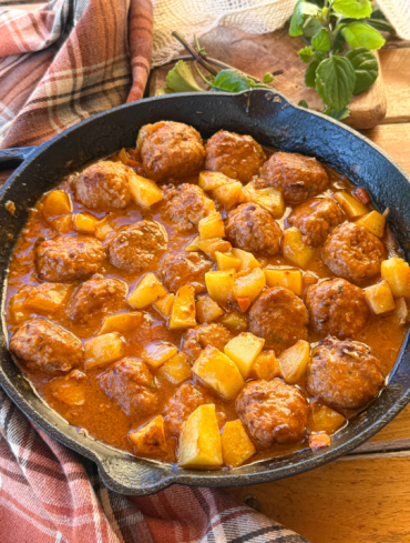 Albóndigas en salsa caseras con patatas al horno, una receta tradicional con salsa de verduras y caldo de pollo.