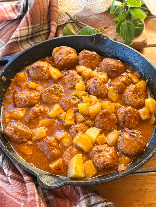 Albóndigas en salsa caseras con patatas al horno, una receta tradicional con salsa de verduras y caldo de pollo.