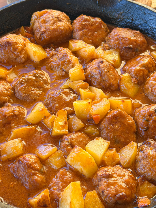 Albóndigas en salsa caseras con patatas al horno, una receta tradicional con salsa de verduras y caldo de pollo.