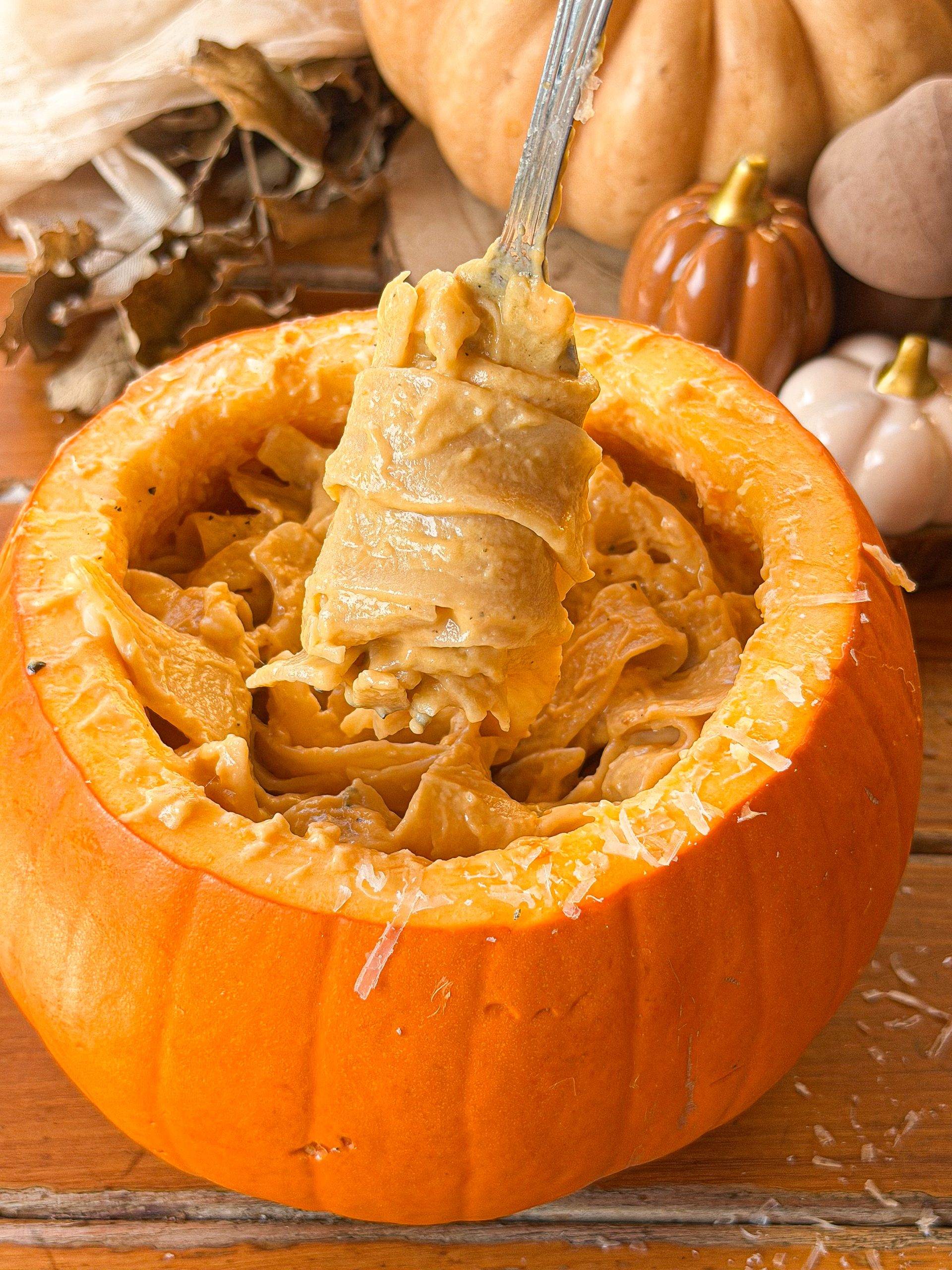 Pappardelle con crema de calabaza y queso fundido, servidos en una calabaza con queso rallado y tomillo fresco.