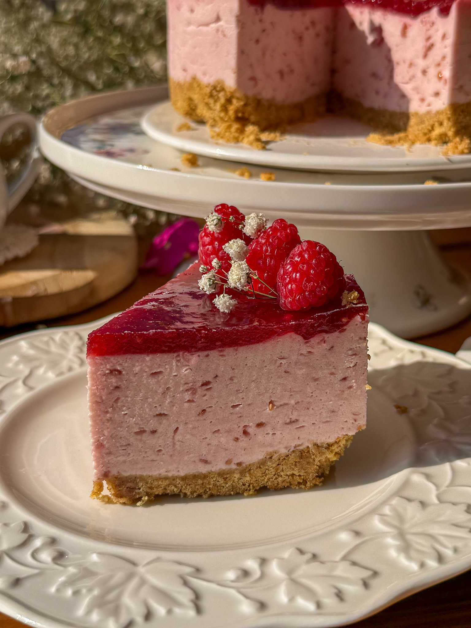 Porción de tarta mousse de frambuesas con textura cremosa y base crujiente