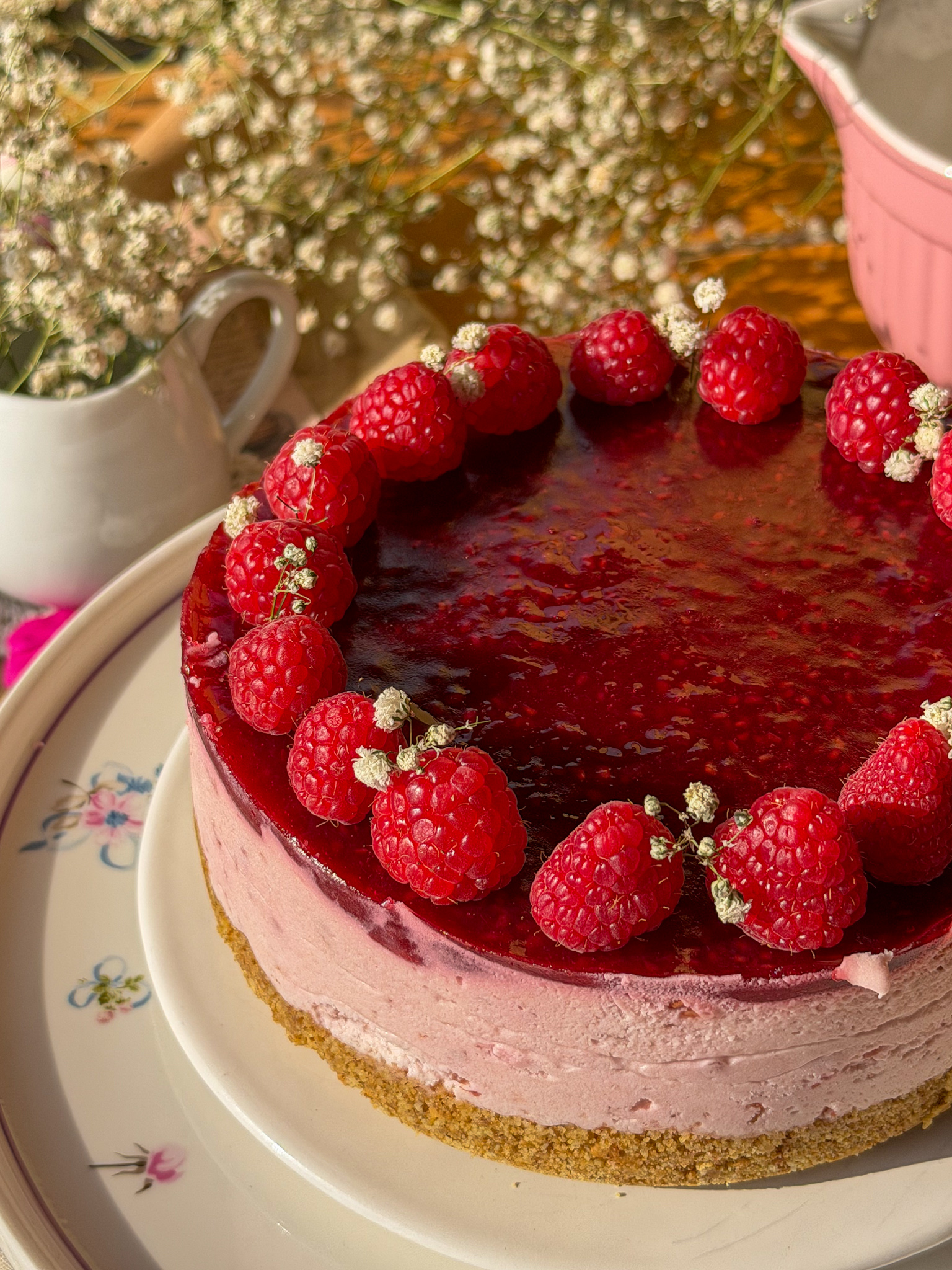 Tarta mousse de frambuesas sin horno con cobertura de frutos rojos y frambuesas frescas