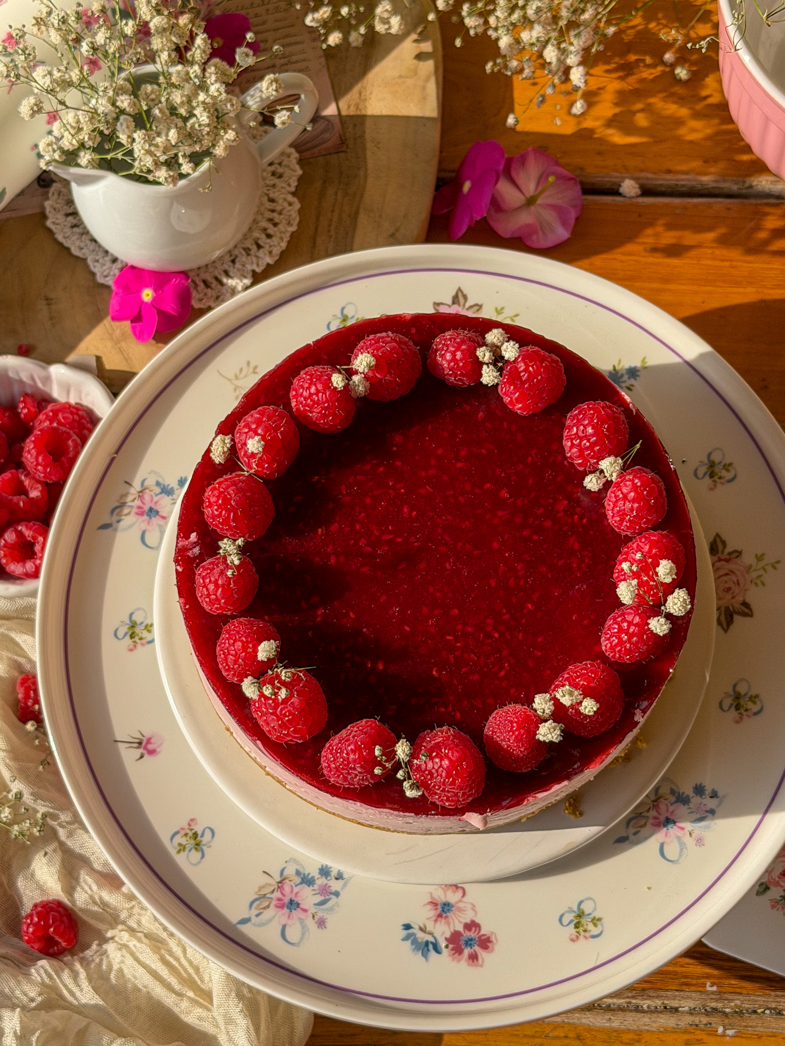 Tarta mousse de frambuesas sin horno con cobertura de frutos rojos y frambuesas frescas